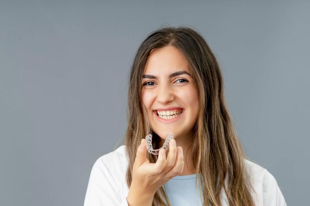 women smiling holding invisalign