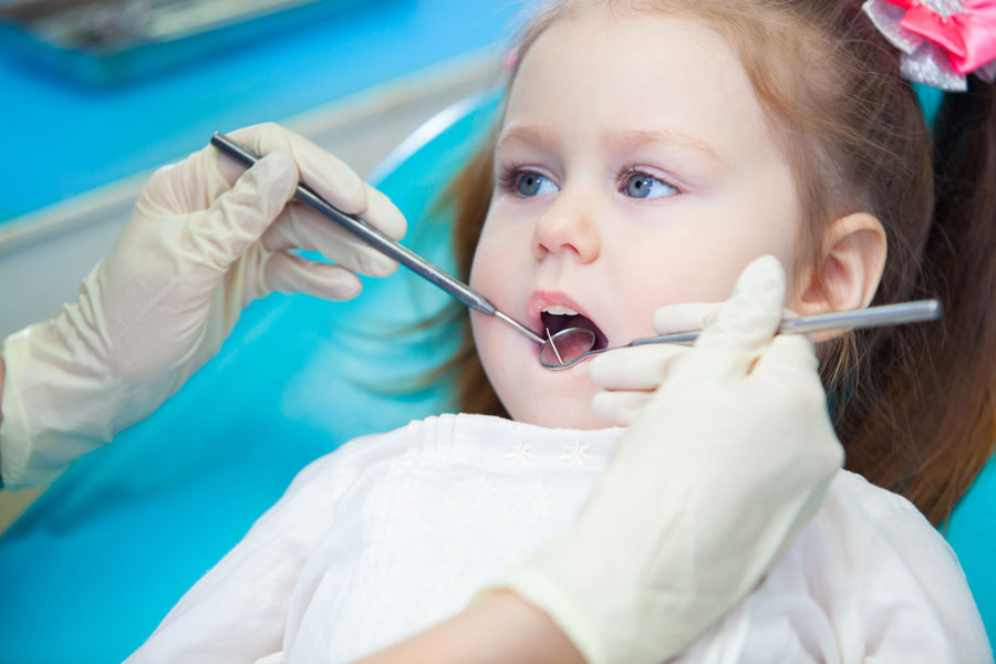 a dentist checking a child's teeth