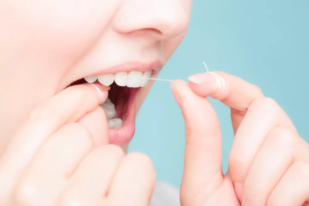 A women Flossing her Teeth