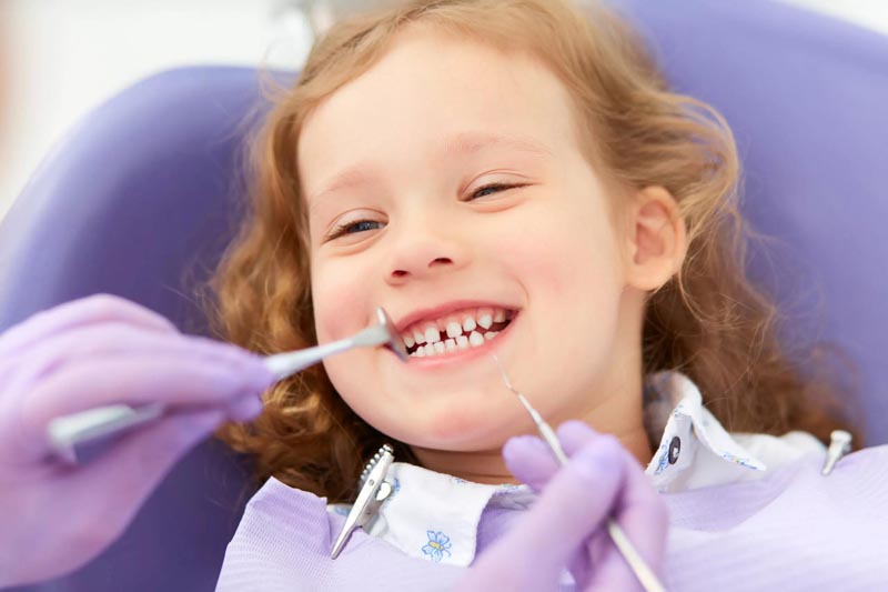 Small girl getting her teeth checked