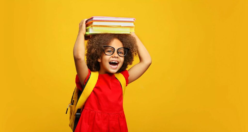 small girl holding books on head
