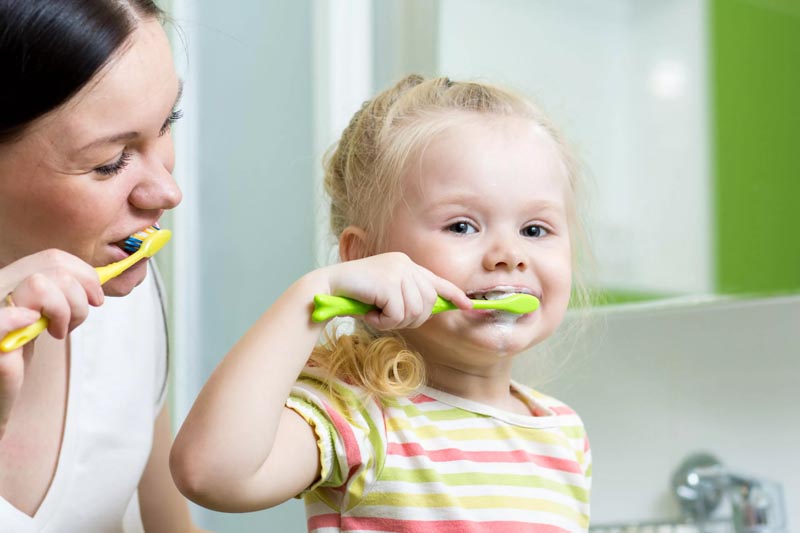 Child brushing her teeth