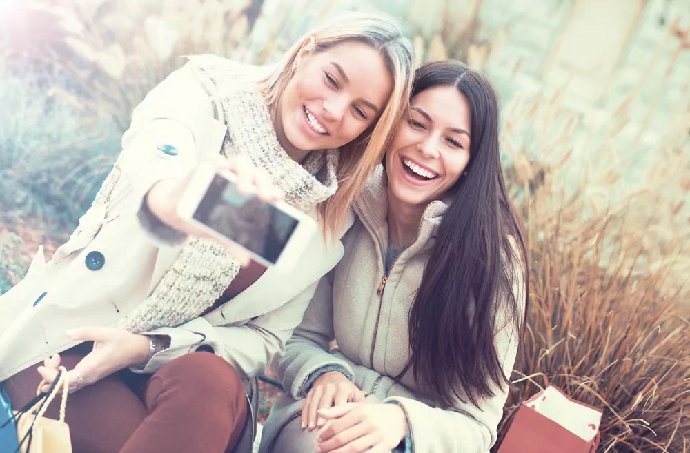 Two women smiling and taking selfi