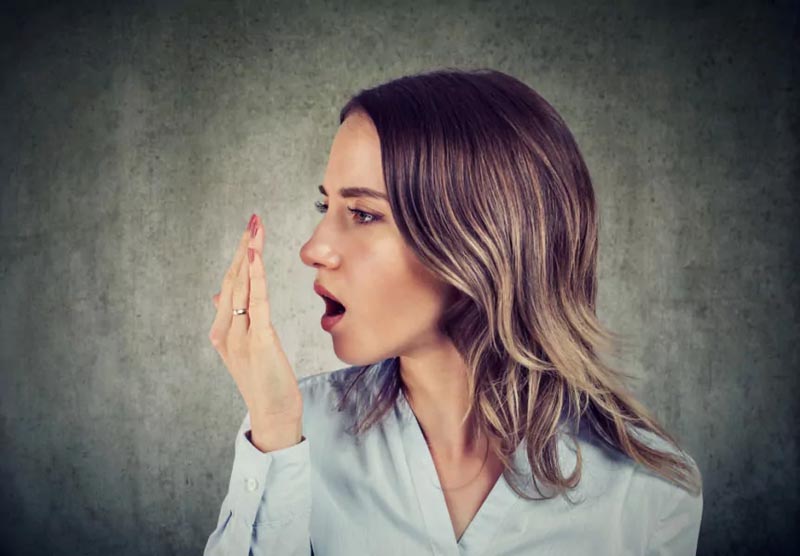 Woman smelling her own breath