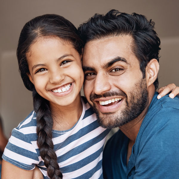 Father hugging his daughter and both are smiling